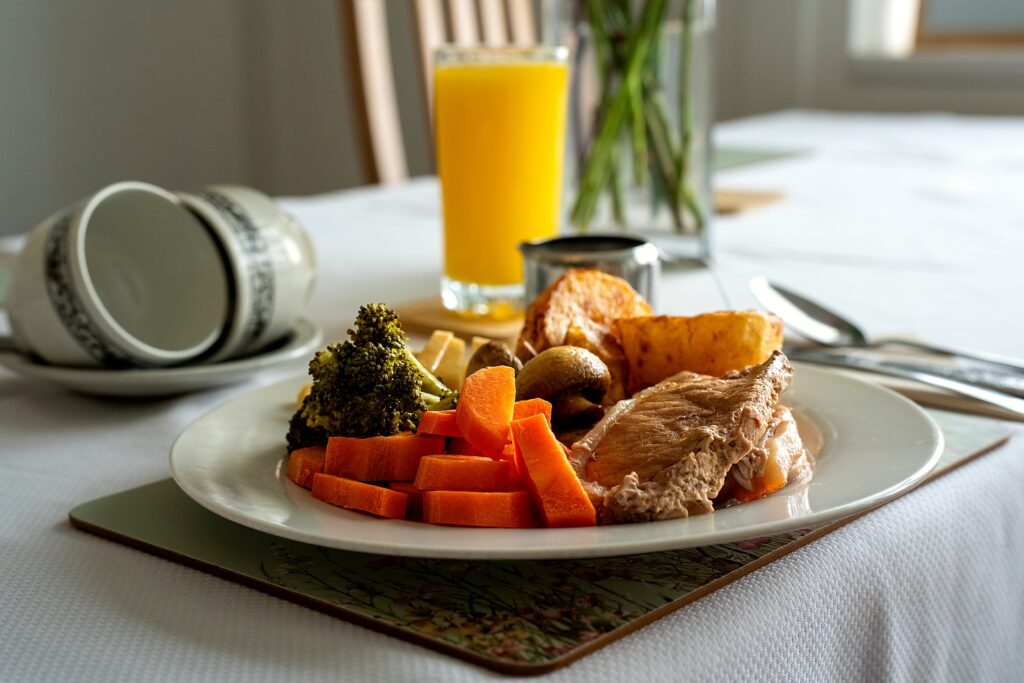 A roast dinner plate with chicken, vegetables and roast potatoes