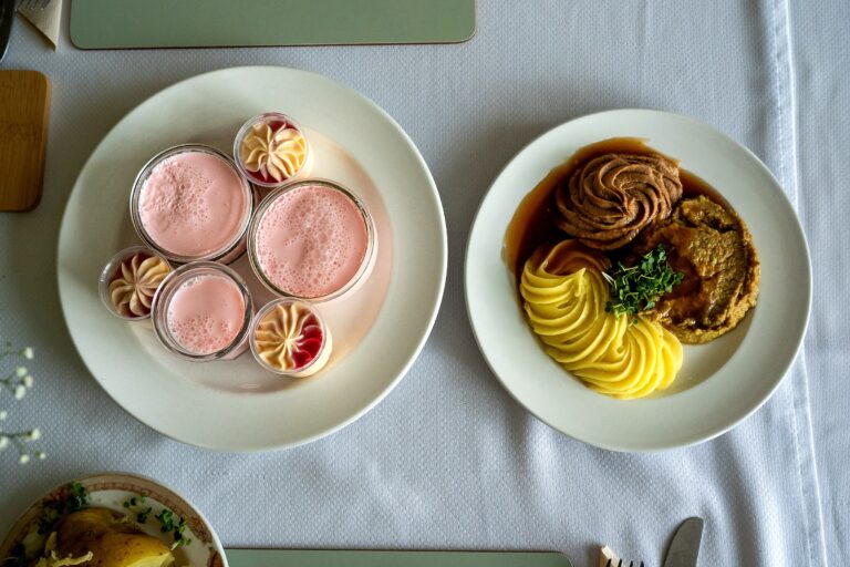A roast dinner and dessert pots served together, viewed from above