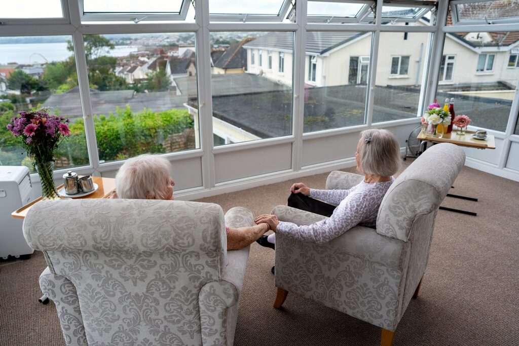 Two residents relaxing together, looking out over the garden