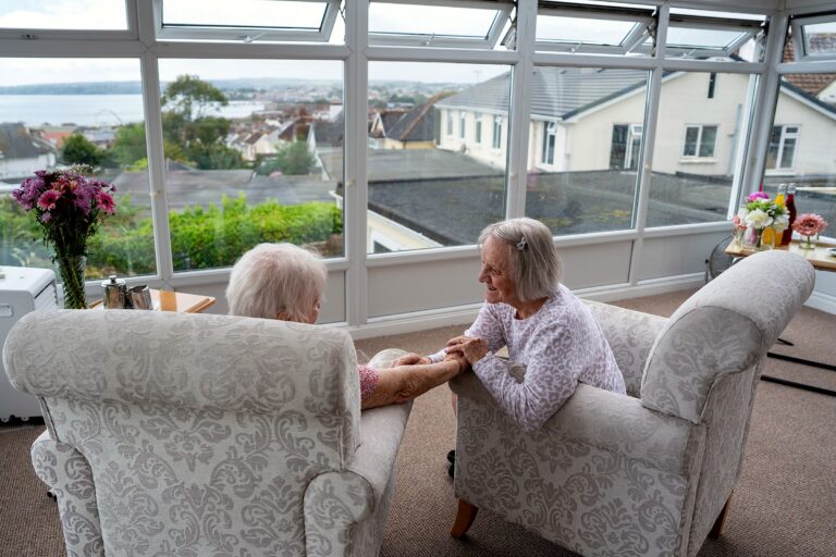 A staff member sharing a laugh with residents at Mount Olivet