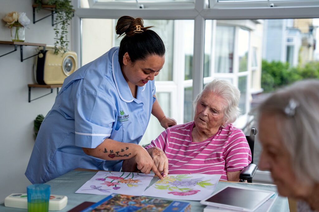 A resident enjoying a colouring activity with support from staff