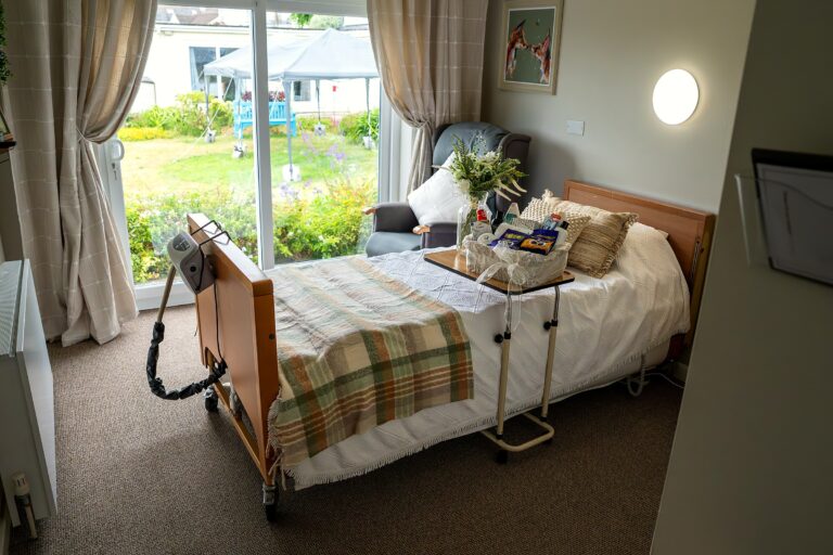 A resident's bedroom at Mount Olivet with a garden-view window and welcome basket