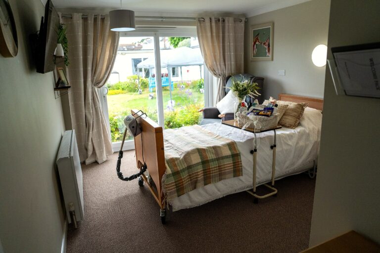 A bedroom at Mount Olivet with a garden-view window and armchair