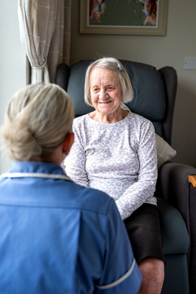 A resident smiling during a visit from a member of staff